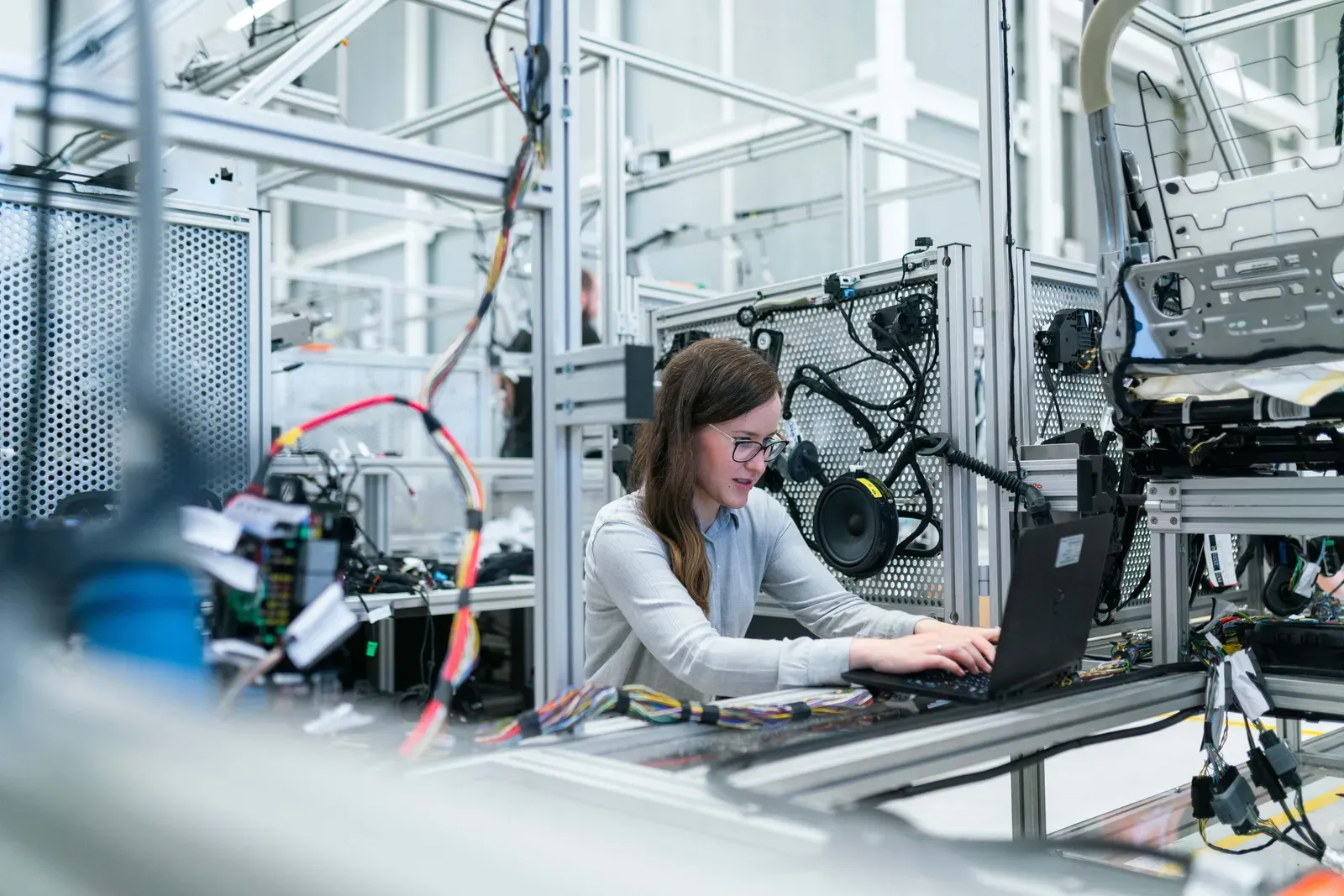 ingénieur électrotechnique instrumentation automatismes qui travaille dans une usine de production sur son ordinateur.