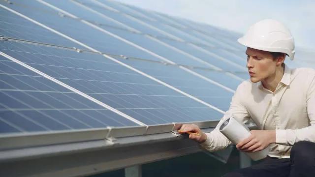 Ingénieur en électricité travaillant sur des panneaux solaires.