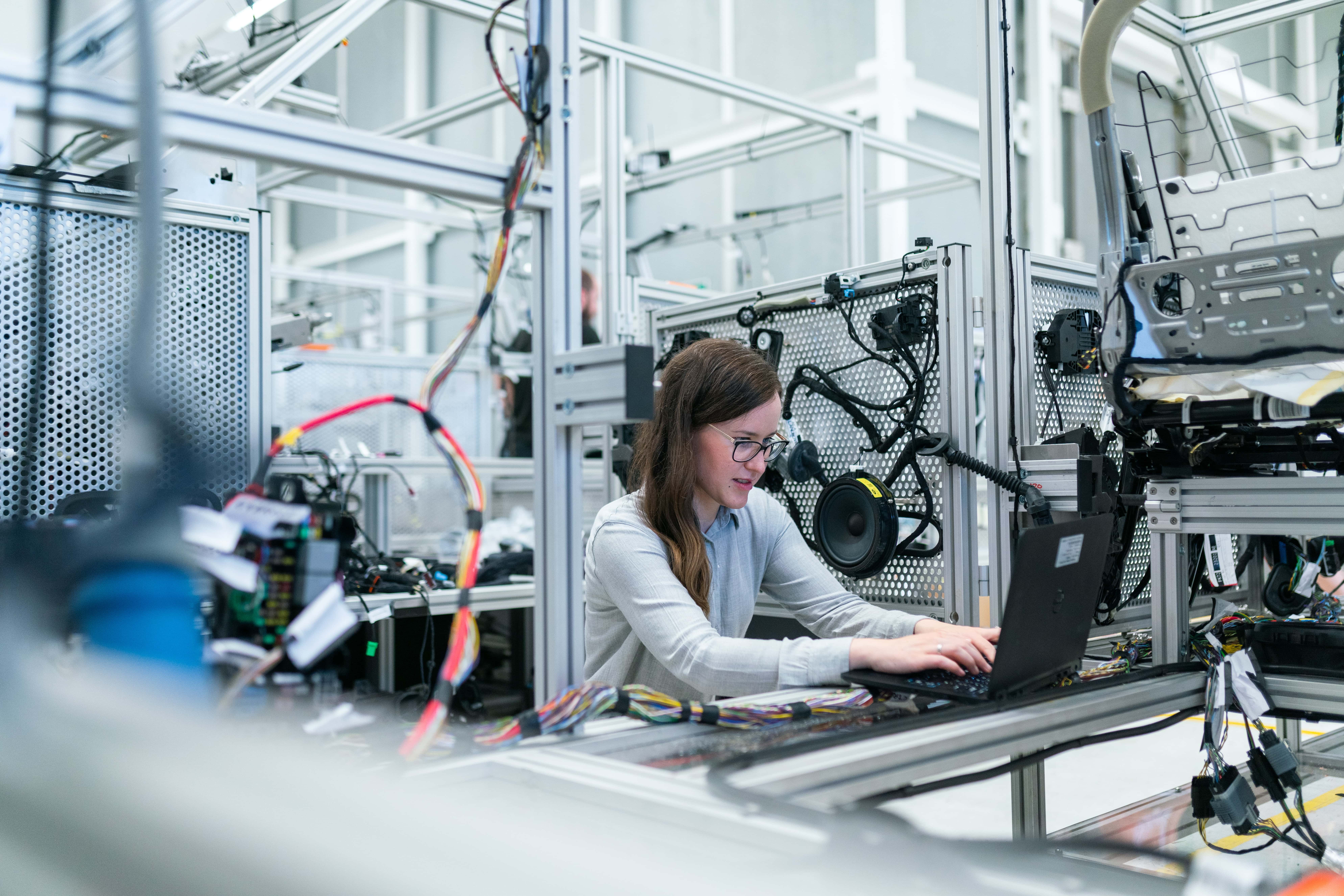 ingénieur électrotechnique instrumentation automatismes qui travaille dans une usine de production sur son ordinateur.